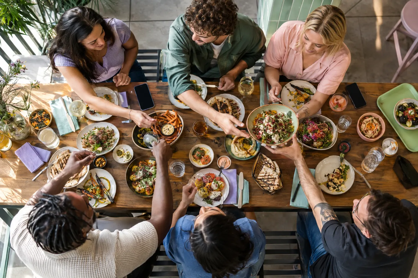 Gasten delen verschillende gerechten rond een tafel.